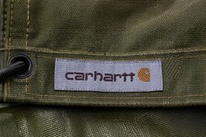 Taffeta woven clothing label sewn on heavy duty canvas tarp showing durable tight weave and clear detail