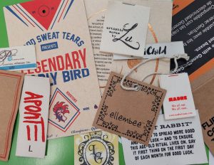 Kraft paper tags and cotton printed labels displayed together, showcasing eco-friendly branding options for sustainable fashion products.