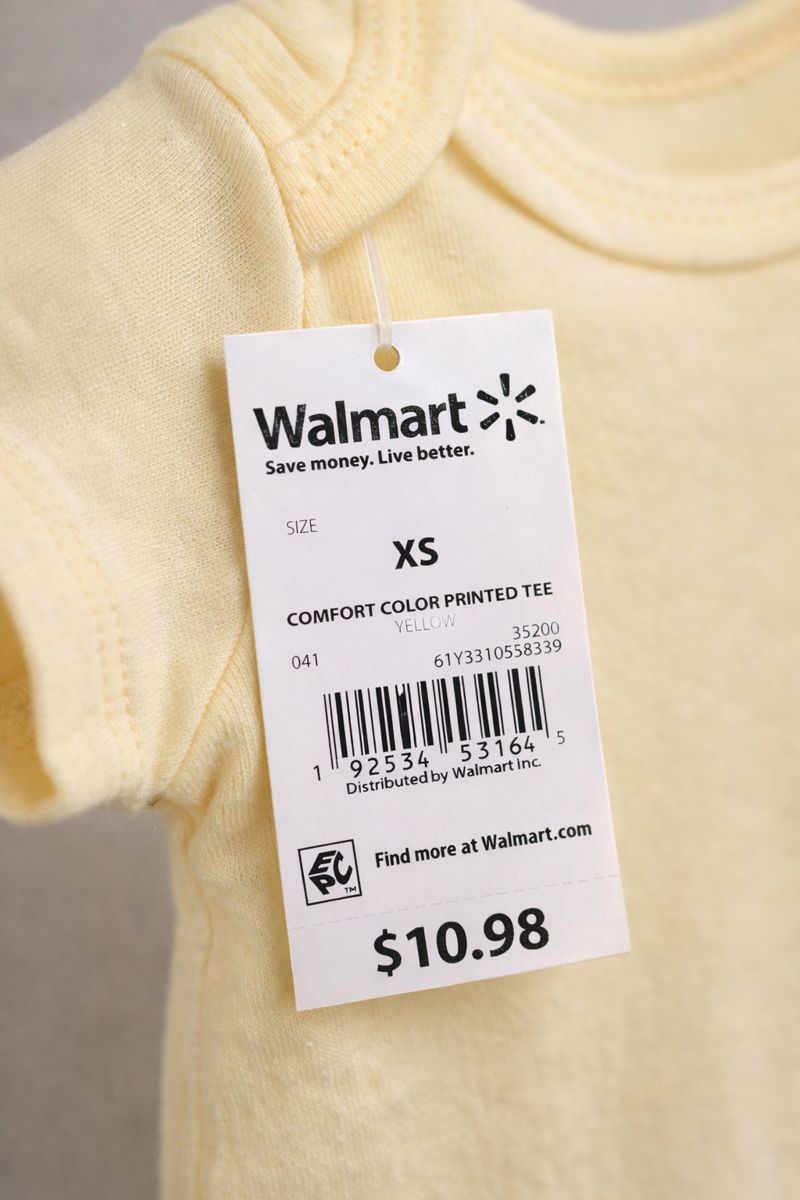 Pale yellow infant onesie with a Walmart RFID hang tag attached under the sleeve using a clear plastic fastener