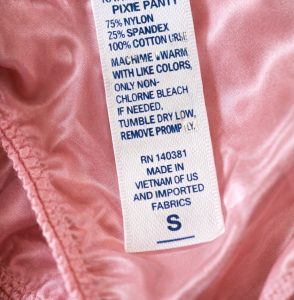 permanent satin care label sewn inside garment showing washing instructions and RN number